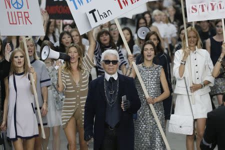 German designer Karl Lagerfeld appears with models who stage a demonstration at the end of his Spring/Summer 2015 women's ready-to-wear collection for French fashion house Chanel during Paris Fashion Week September 30, 2014. REUTERS/Gonzalo Fuentes