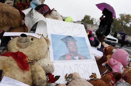 A woman walks by a memorial set up for Michael Brown in Ferguson, Missouri, October 10, 2014. REUTERS/Jim Young