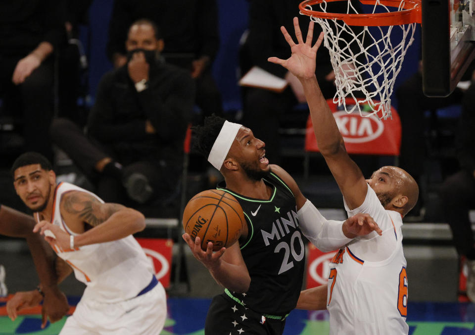 Josh Okogie, center, of the Minnesota Timberwolves shoots as Taj Gibson, right, and Obi Toppin, left, of the New York Knicks defend during the first half of an NBA basketball game Sunday, Feb. 21, 2021, in New York. (Sarah Stier/Pool Photo via AP)