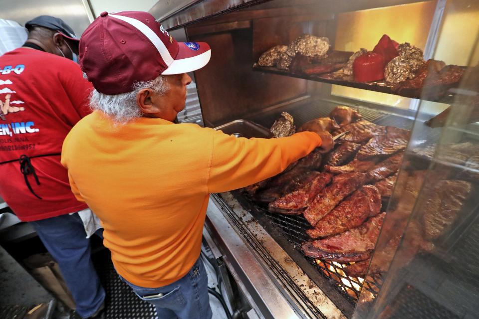 Bar-B-Q Heaven owner Ronald Jones flips meat as he works with employees Tuesday, May 11, 2021 at his Indianapolis bar-b-q restaurant which turned 70 in May 2021.