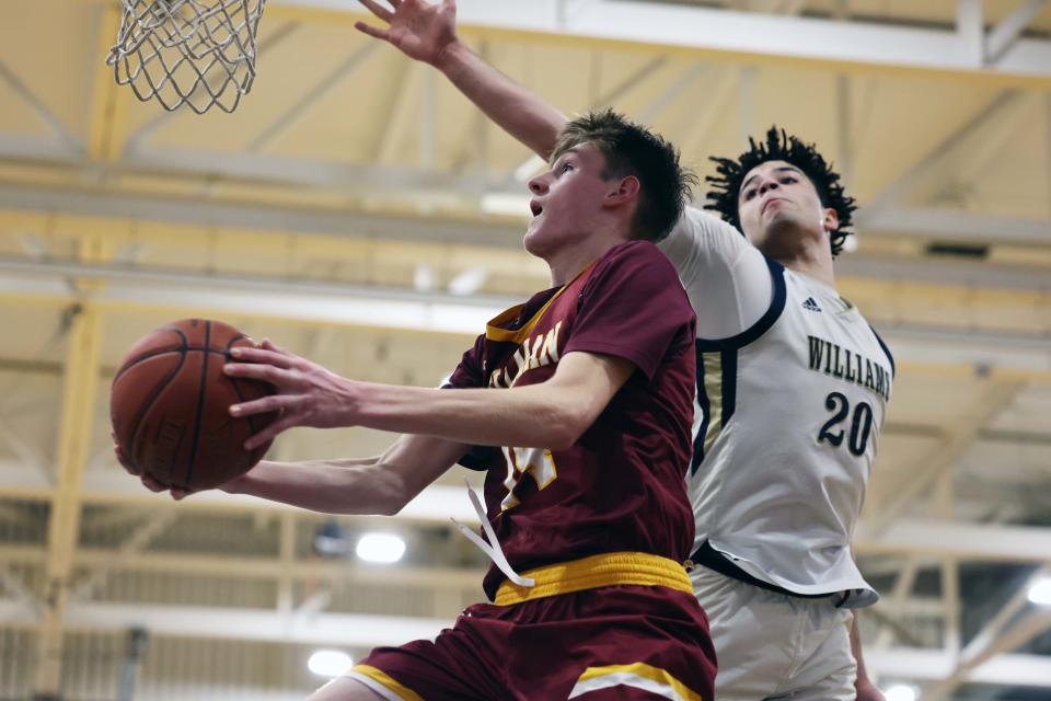 Cardinal Spellman's Luke McSharry takes a shot at the basket around Archbishop Williams defender Josh Campbell Scituate High School on Wednesday, March 15, 2023.  