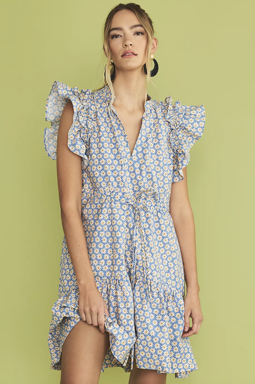 blonde model against green background wearing blue and yellow floral print By Anthropologie Ruffle-Sleeve Dress (photo via Anthropologie)