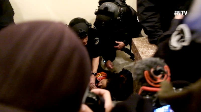 Police help a woman, who was shot, as she lies on the floor, after supporters of U.S. President Donald Trump entered the Capitol building in Washington DC, U.S. , in this still frame obtained from social media video