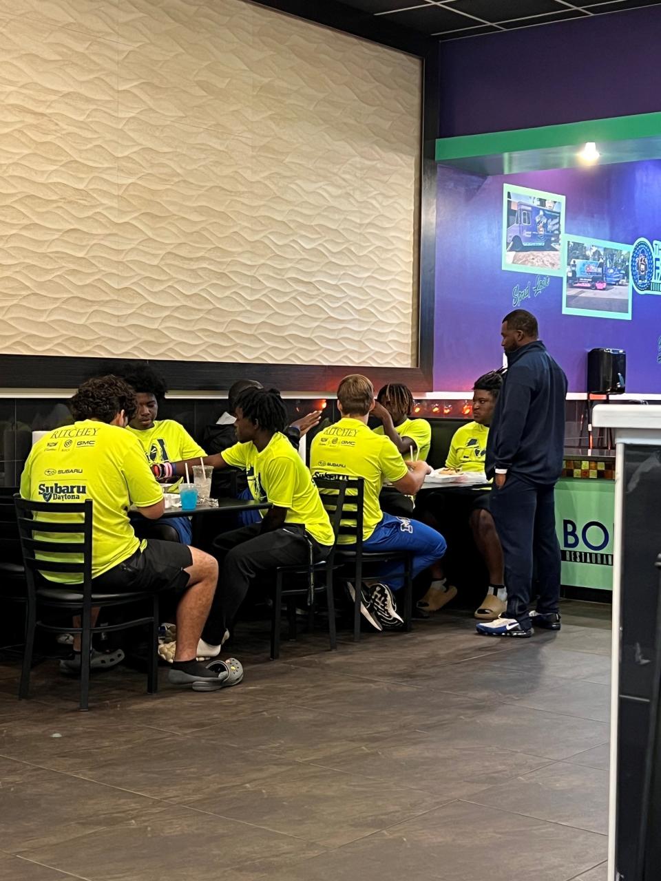 Mainland High School football players eat a meal at Fat Boi Gourmet Potatoes in Daytona Beach last week.