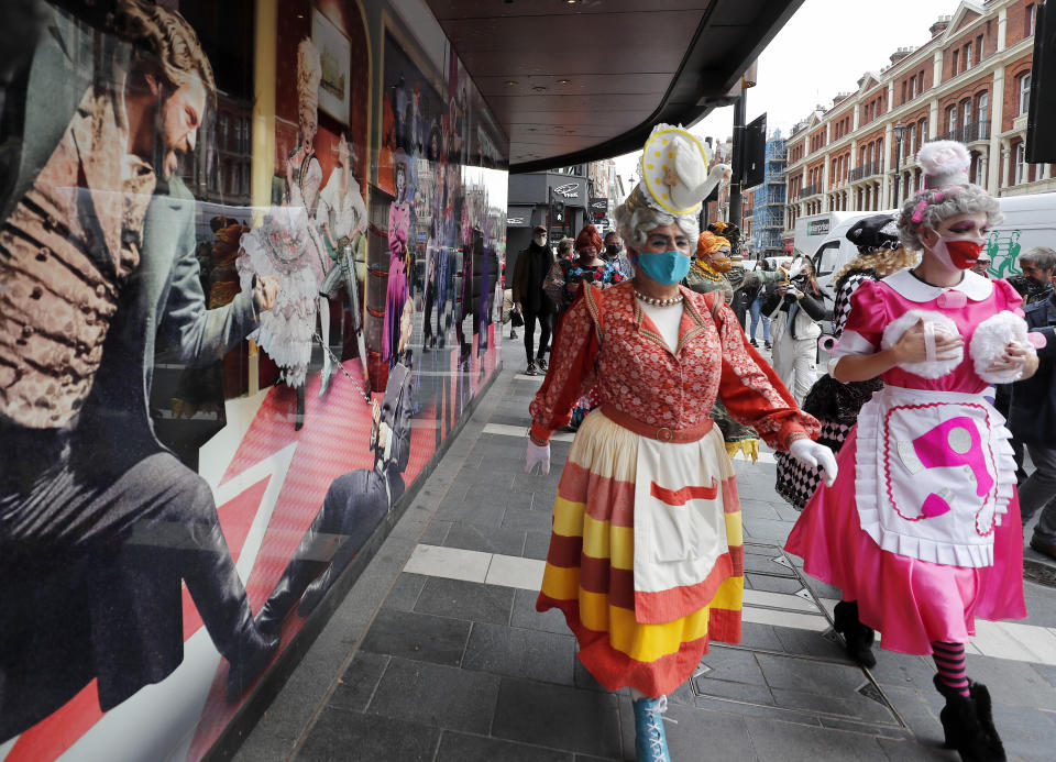 Actors dresses as panto dames march past a boarded up theatre on their way to Parliament to demand more support for the theatre sector amid the COVID-19 pandemic in London, Wednesday, Sept. 30, 2020.(AP Photo/Frank Augstein)