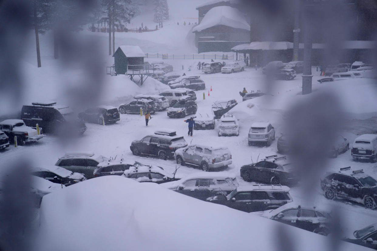People through the parking area of the Alpine Base Area at Palisades Tahoe during a winter storm Friday, Feb. 24, 2023, in Alpine Meadows, Calif. California and other parts of the West are facing heavy snow and rain from the latest winter storm to pound the United States. (AP Photo/John Locher)