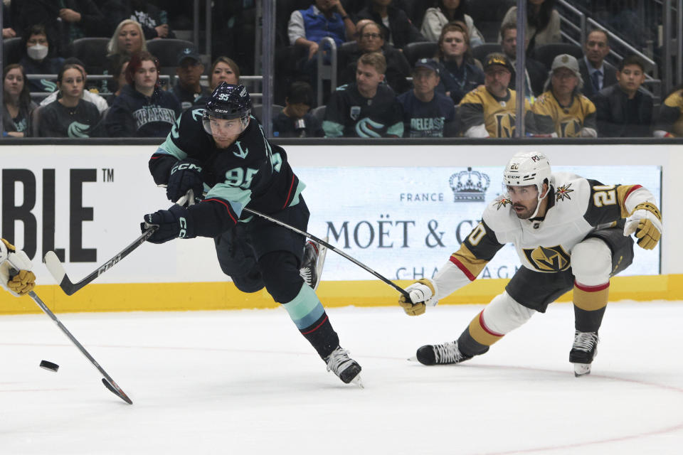 Seattle Kraken left wing Andre Burakovsky shoots the puck as Vegas Golden Knights center Chandler Stephenson defends during the second period of an NHL hockey game, Saturday, Oct. 15, 2022, in Seattle. (AP Photo/Jason Redmond)