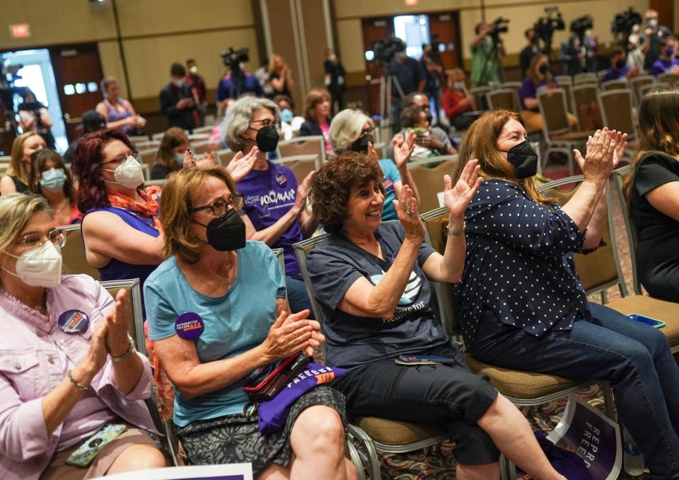 Members of Fems for Democracy cheer on a speaker during a news conference for Reproductive Freedom For All at the Lansing Center in downtown Lansing on Monday, July 11, 2022.