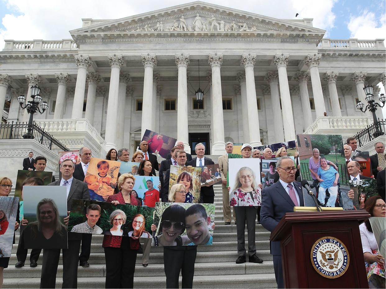 Senate Minority Leader Chuck Schumer speaks while flanked by Senate Democrats holding photos of people who would lose their health coverage under the Senate Republicans healthcare bill during a press conference at the US Capitol on 27 June 2017: Mark Wilson/Getty Images