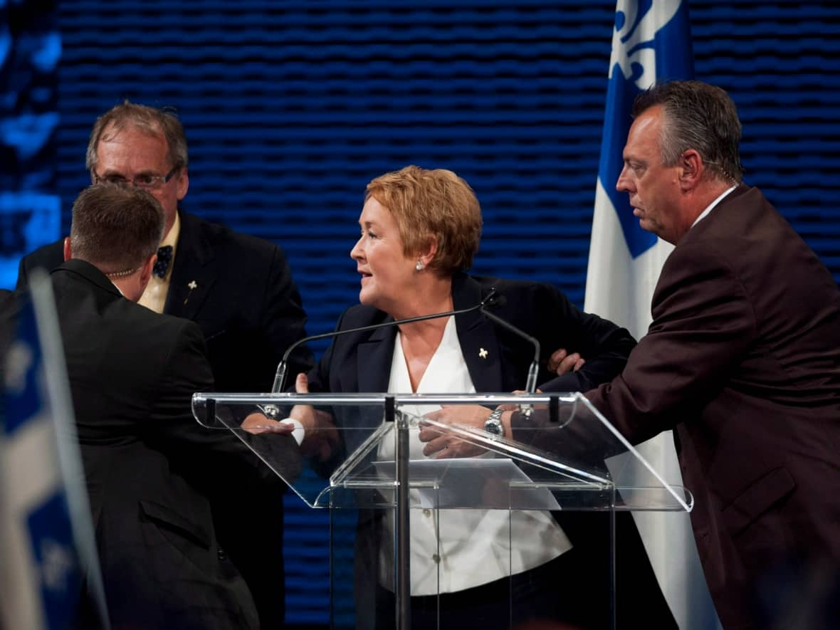 Parti Québécois leader Pauline Marois is removed from the stage by Sûreté du Québec officers as she was speaking to supporters in Montreal, Tuesday, September 4, 2012 following her election win.  (Graham Hughes/The Canadian Press - image credit)