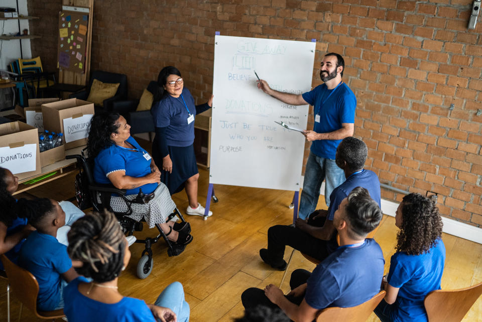 Mid adult man talking in a meeting at a community center - including a disabled person