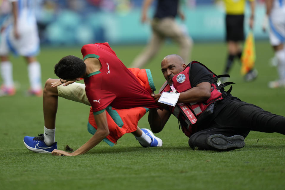 A pitch invasion near the end of the second cause led to an hour-plus delay before the conclusion of the match, which ended with Morocco winning 2-1 in the Olympic opener. (AP Foto/Silvia Izquierdo)