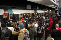 Commuters wait to catch a subway train Tuesday, Dec. 10, 2019 in Paris. Only about a fifth of French trains ran normally Tuesday, frustrating tourists finding empty train stations, and most Paris subways were at a halt. French airport workers, teachers and others joined nationwide strikes Tuesday as unions cranked up pressure on the government to scrap changes to the national retirement system. (AP Photo/Francois Mori)