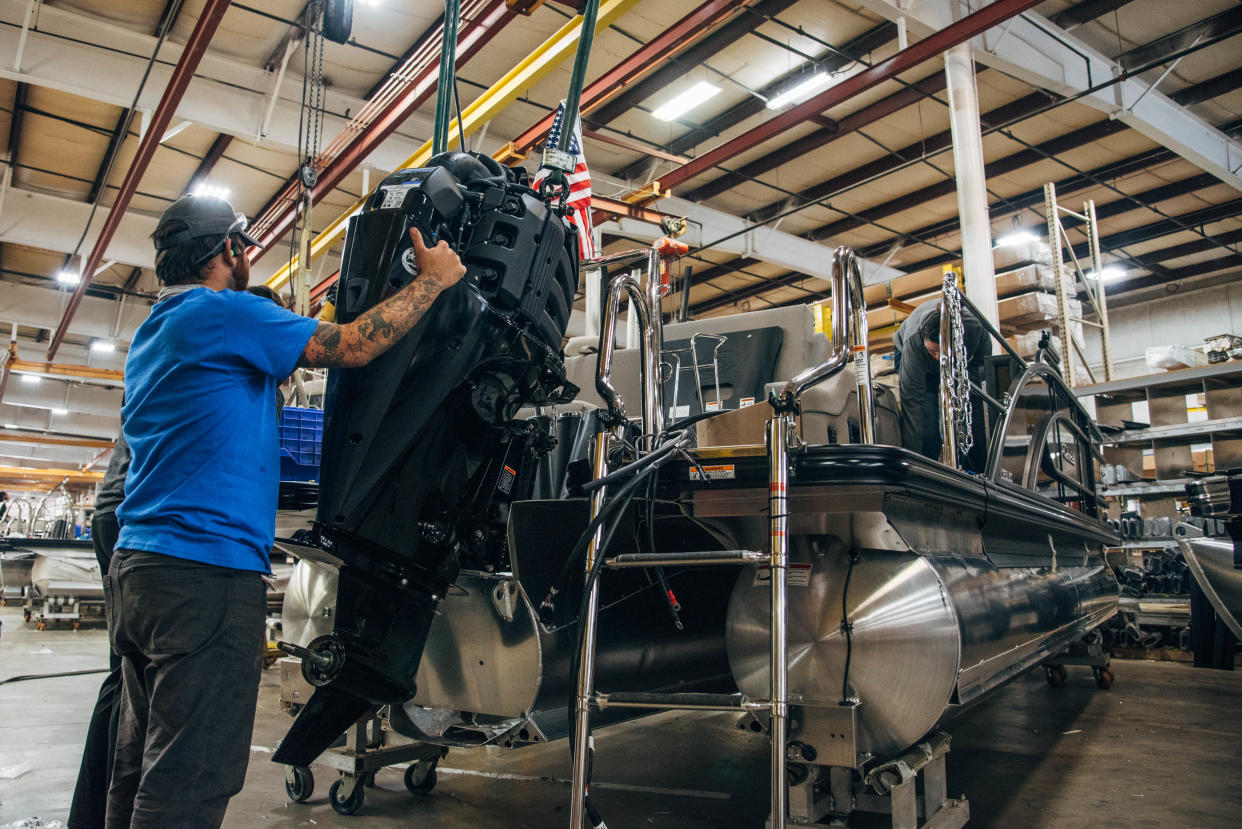 A motor is installed on a new pontoon at the Barletta Boat plant in Bristol.