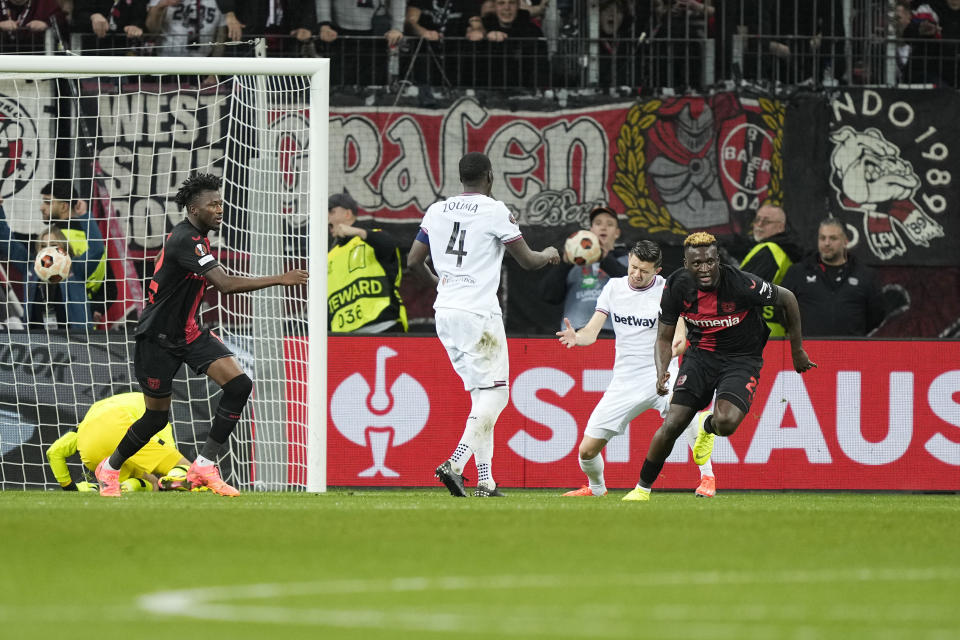 Leverkusen's Victor Boniface, right, celebrates after scoring his side's second goal during the Europa League quarterfinals first leg soccer match between Bayer 04 Leverkusen and West Ham United at the BayArena in Leverkusen, Germany, Thursday, April 11, 2024. (AP Photo/Martin Meissner)