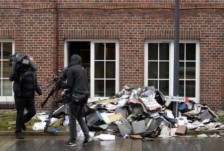 Members of a television crew are seen beside burned files and documents in front of a building of German newspaper Hamburger Morgenpost in Hamburg January 11, 2015. REUTERS/Fabian Bimmer