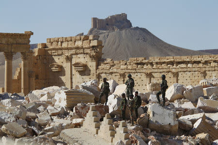 FILE PHOTO: Syrian army soldiers stand on the ruins of the Temple of Bel in the historic city of Palmyra, in Homs Governorate, Syria April 1, 2016. REUTERS/Omar Sanadiki/File Photo