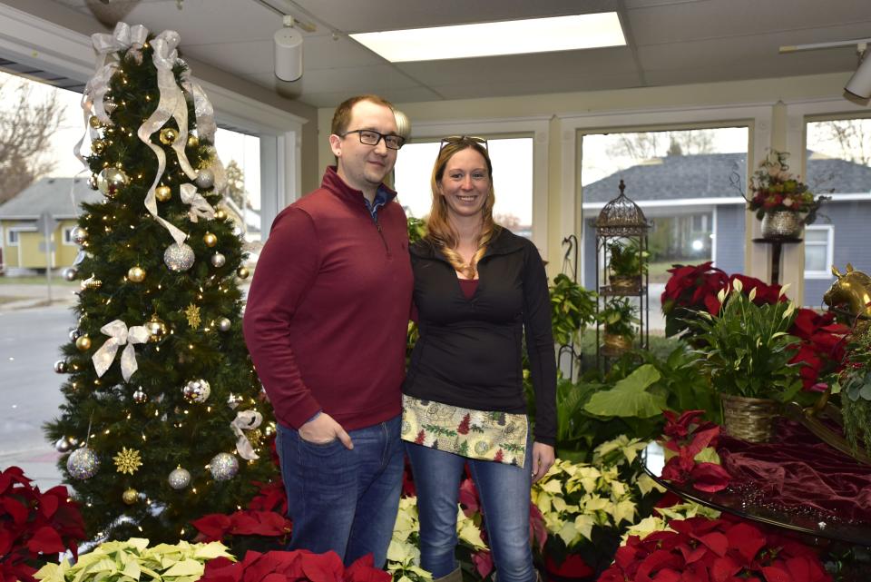 Flower Niche owners Vincent and Jessica Herbert stand in front of the Christmas flower arrangements inside their shop located 1902 Water St., in Port Huron, on Tuesday, Nov. 22, 2022. The husband and wife duo officially bought the building on Nov. 10 from his grandmother Vivian Herbert, who owned it for 40 years, and are planning to expand the business by redoing the floors and revamping the upstairs apartment while keeping the historic look of the building.