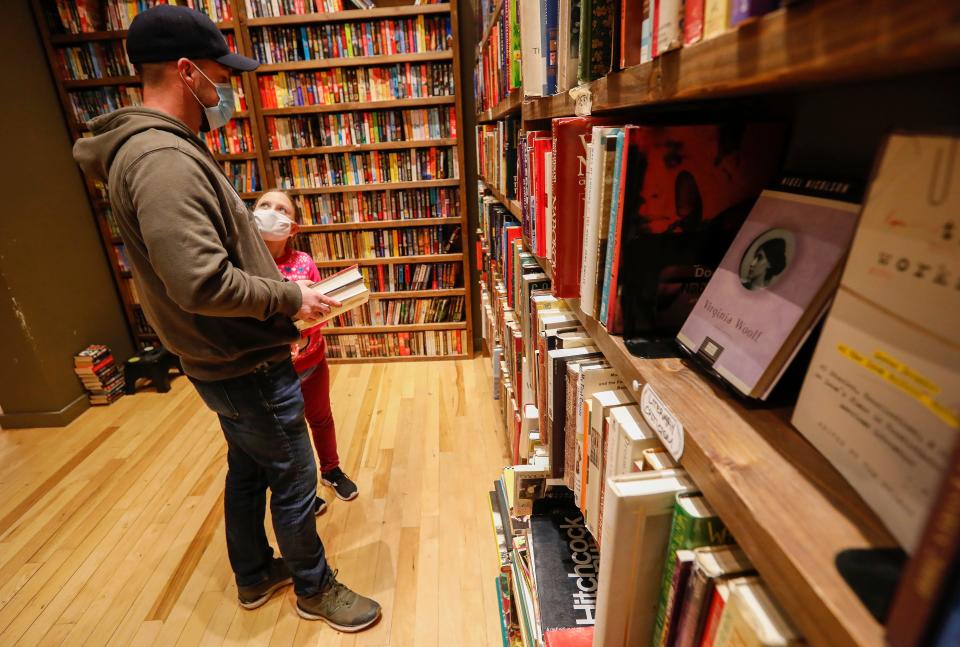 Customers shop for books at Bookmarx in downtown Springfield during Small Business Saturday on Saturday, Nov. 28, 2020.