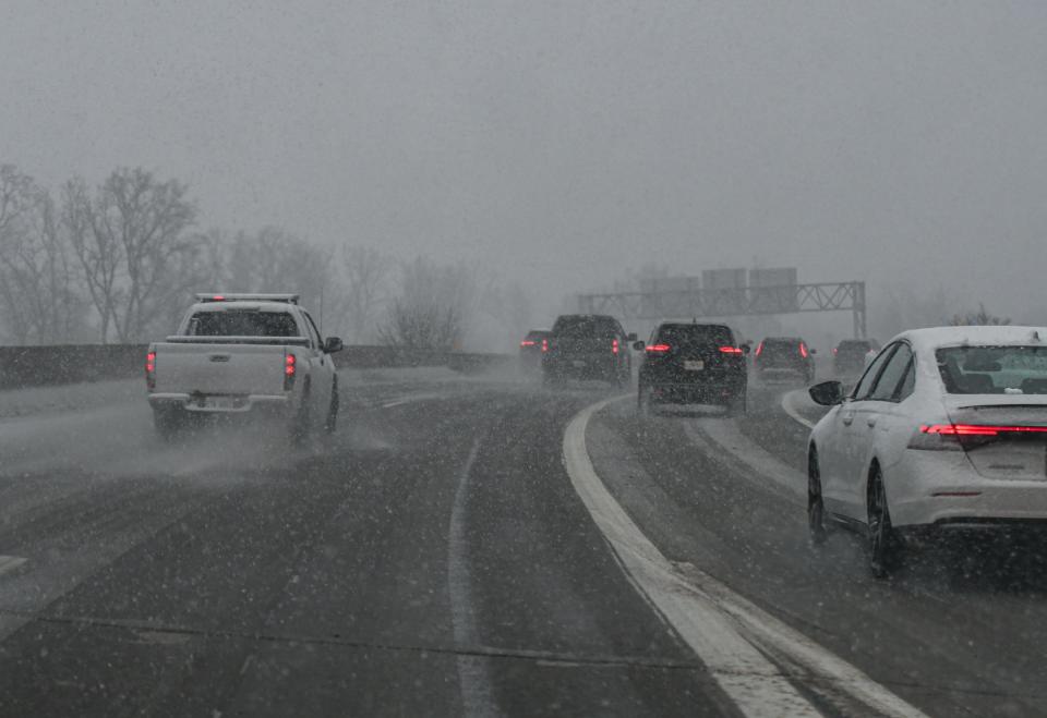 Traffic moves slowly at the I-496/US-127 south interchange, as snow falls late Friday afternoon, Jan. 12, 2024.