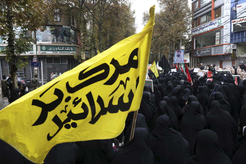 A banner in Persian that reads, "Death to Israel," is carried as mourners attend a funeral procession of Revolutionary Guard member Morteza Ebrahimi, who was killed during recent protests, in Shahriar, Iran, some 40 kilometers (25 miles) southwest of the capital, Tehran, Wednesday, Nov. 20, 2019. Ebrahimi was killed during protests over government-set fuel prices rising last week, demonstrations that quickly spiraled in violence. (AP Photo/Vahid Salemi)