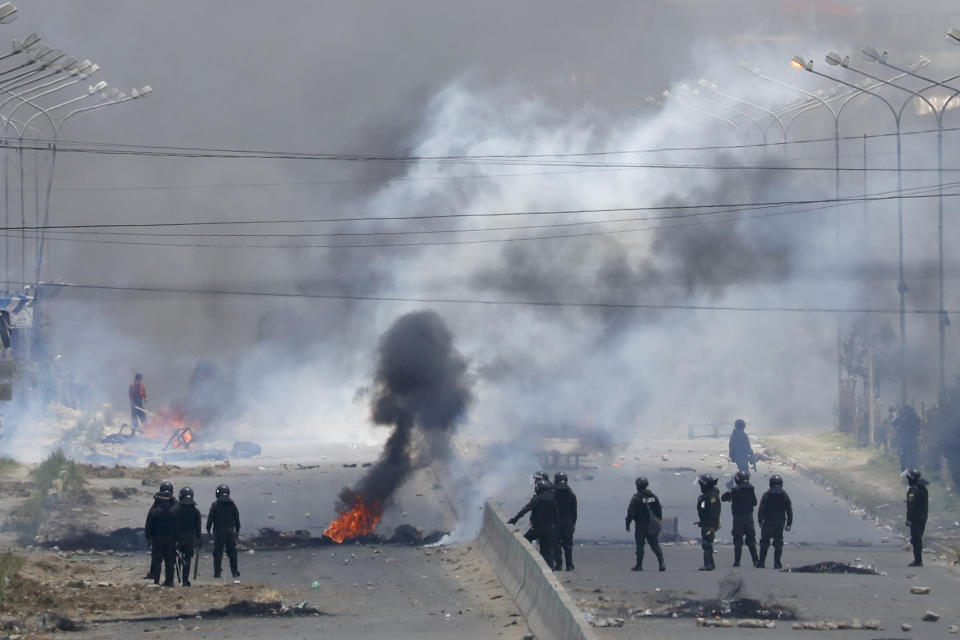 Security forces stand by barricades constructed by supporters of former President Evo Morales along the road leading to the state-own Senkata filling gas plant in El Alto, on the outskirts of La Paz, Bolivia, Tuesday, Nov. 19, 2019. Morales' backers have taken to the streets asking for his return since he resigned on Nov. 10 under pressure from the military after weeks of protests against him over a disputed election he claim to have won. (AP Photo/Natacha Pisarenko)