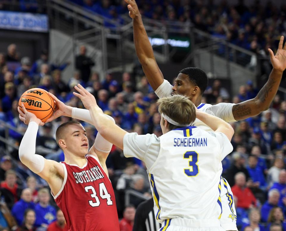 South Dakota's Tasos Kamateros is heavily guarded by South Dakota State's Baylor Scheierman and Doug Wilson in a semifinal game on Monday, March 7, 2022, at the Summit League Tournament at the Denny Sanford Premier Center in Sioux Falls.