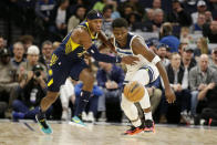 Minnesota Timberwolves guard Anthony Edwards, right, and Indiana Pacers center Myles Turner, left, vie for a loose ball in the first quarter of an NBA basketball game Wednesday, Dec. 7, 2022, in Minneapolis. (AP Photo/Andy Clayton-King)