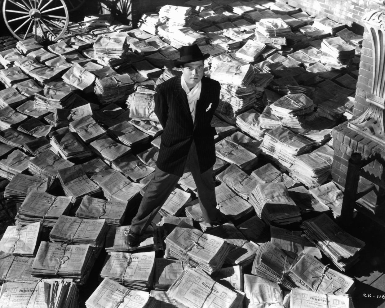 Orson Welles standing on stacks of newspapers in a scene from the film 'Citizen Kane', 1941. (Photo by RKO Radio Pictures/Getty Images)