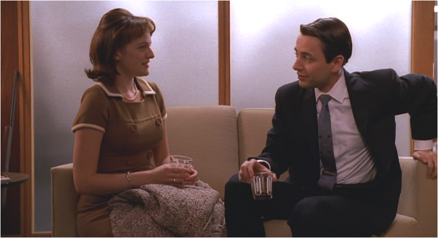 Peggy Olson and Pete Campbell sitting and talking in an office setting from the TV show "Mad Men"