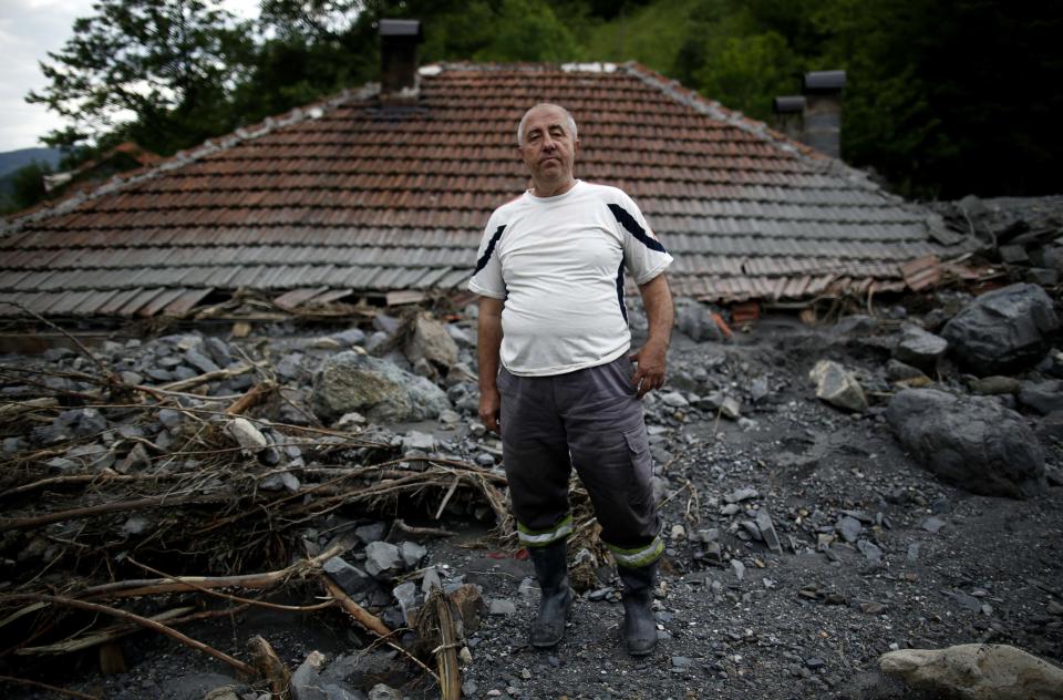 Serif Gracic, poses on the roof of his flood-damaged house in Topcic Polje