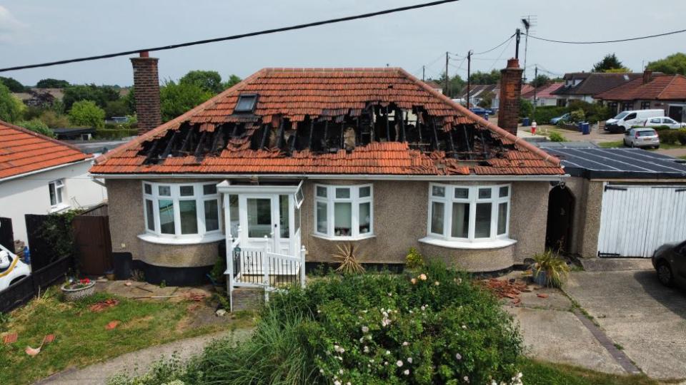 Parts of the bungalow's roof are blackened and missing where the fire ripped through.