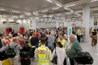 Passengers are seen at Thomas Cook check-in points at Mallorca Airport after the world's oldest travel firm collapsed, in Palma de Mallorca