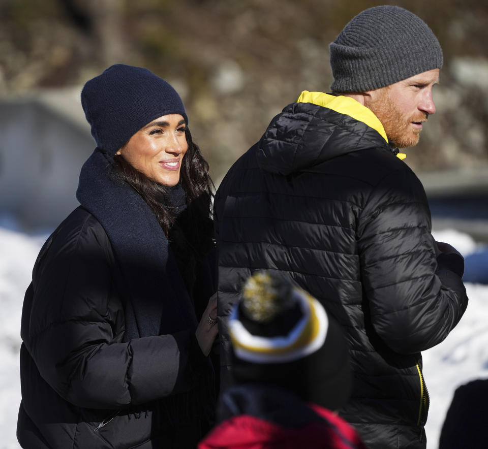 Prince Harry and Meghan Markle, the Duke and Duchess of Sussex, walk together after Harry slid down the track on a skeleton sled while attending an Invictus Games training camp, in Whistler, British Columbia, Thursday, Feb. 15, 2024. Invictus Games Vancouver Whistler 2025 is scheduled to take place from Feb. 8 to 16, 2025 and will for the first time feature winter sports. (Darryl Dyck/The Canadian Press via AP)