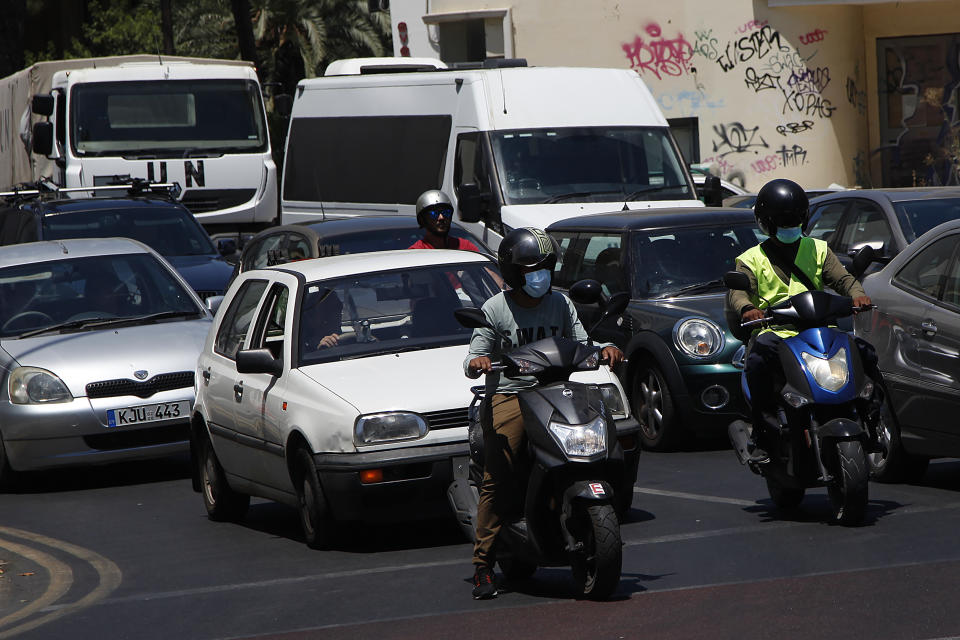 Motorcyclists wear face masks in capital Nicosia, Cyprus, Friday, July 31, 2020. Cyprus has made mask-wearing compulsory in all indoor areas where people gather in large numbers like malls and supermarkets and is significantly ramping up random coronavirus testing at it's two main airports following an upsurge of new confirmed cases in the last week that has alarmed authorities. (AP Photo/Petros Karadjias)