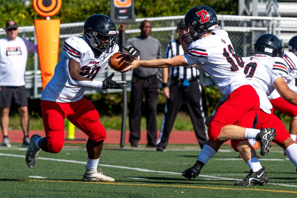 Durfee’s Eli Chace hands off to Lawrence Harrison during Saturday’s game against Taunton.