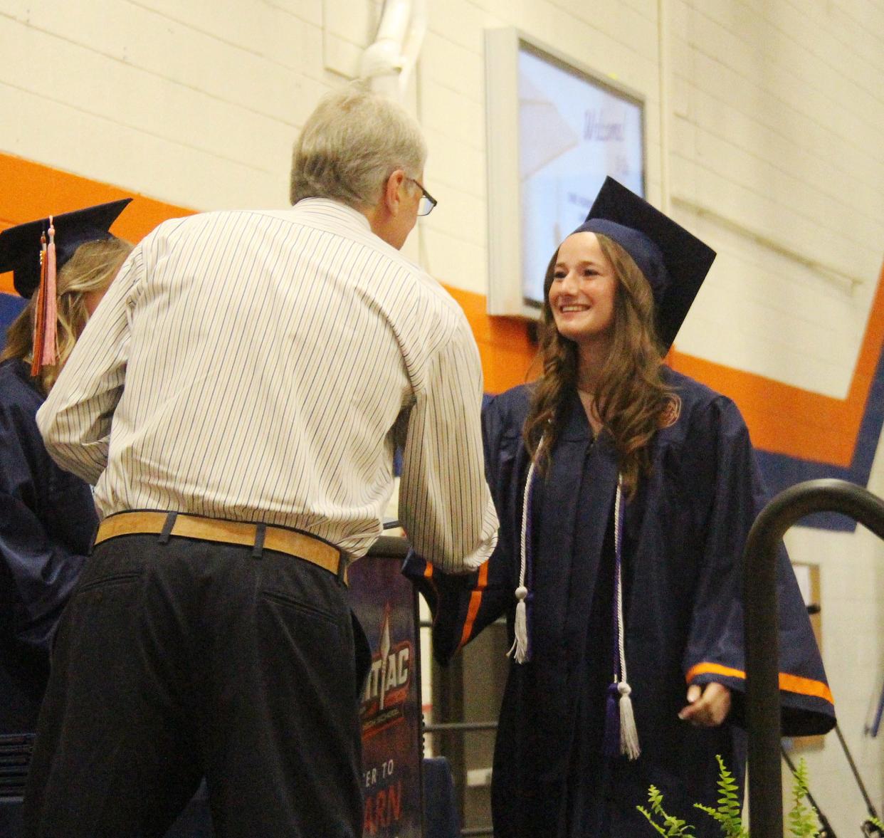 Julie Godart is all smiles as she receives congratulations and a diploma from PTHS District 90 Board Vice President Nick Sartoris on May 21.