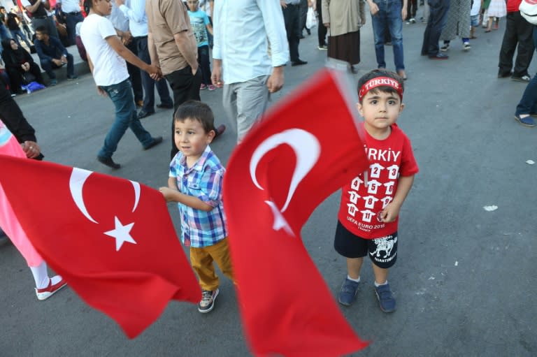 Children wave Turkish flags as Pro-Erdogan supporters gather during a rally against the military coup at Kizilay Square in Ankara, on July 25, 2016