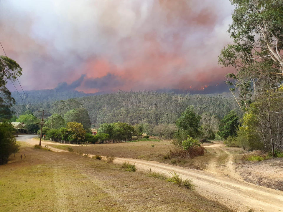 In this Dec. 30, 2019, photo provided by Siobhan Threlfall, a fire approaches the village of Nerrigundah, Australia. The tiny village has been among the hardest hit by Australia's devastating wildfires, about with two thirds of the homes destroyed and a 71-year-old man killed. (AP Photo/Siobhan Threlfall)
