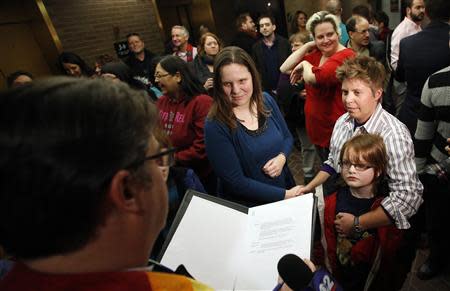 Kim Hackford-Peer (L) marries her partner Ruth Hackford-Peer (R) as Ruth holds their son Casey, 7, at the Salt Lake County office building in Salt Lake City, Utah, December 20, 2013. REUTERS/Jim Urquhart