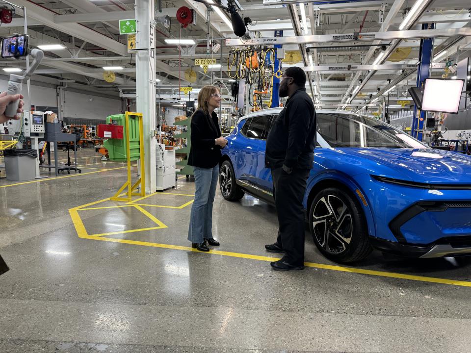 General Motors chair and CEO Mary Barra speaks to a team member inside its EV production facility in Detroit. 