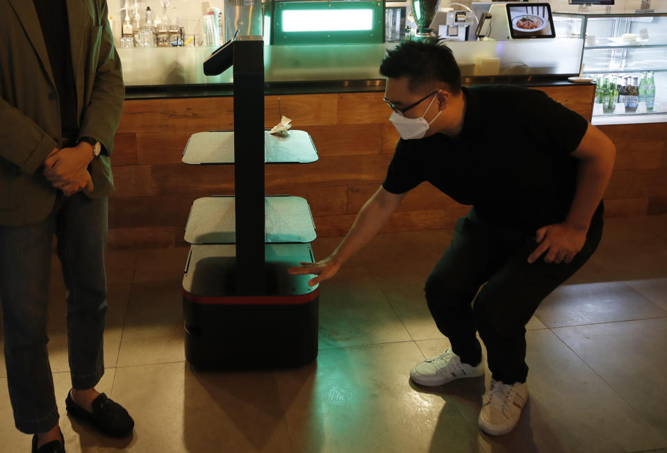 Lee Youngjin, team leader of AI Platform Business Team at KT Corp., speaks about AI serving robot ahead of a demonstration at a restaurant in Seoul, South Korea, Tuesday, Sept. 15, 2020. (AP Photo/Lee Jin-man)