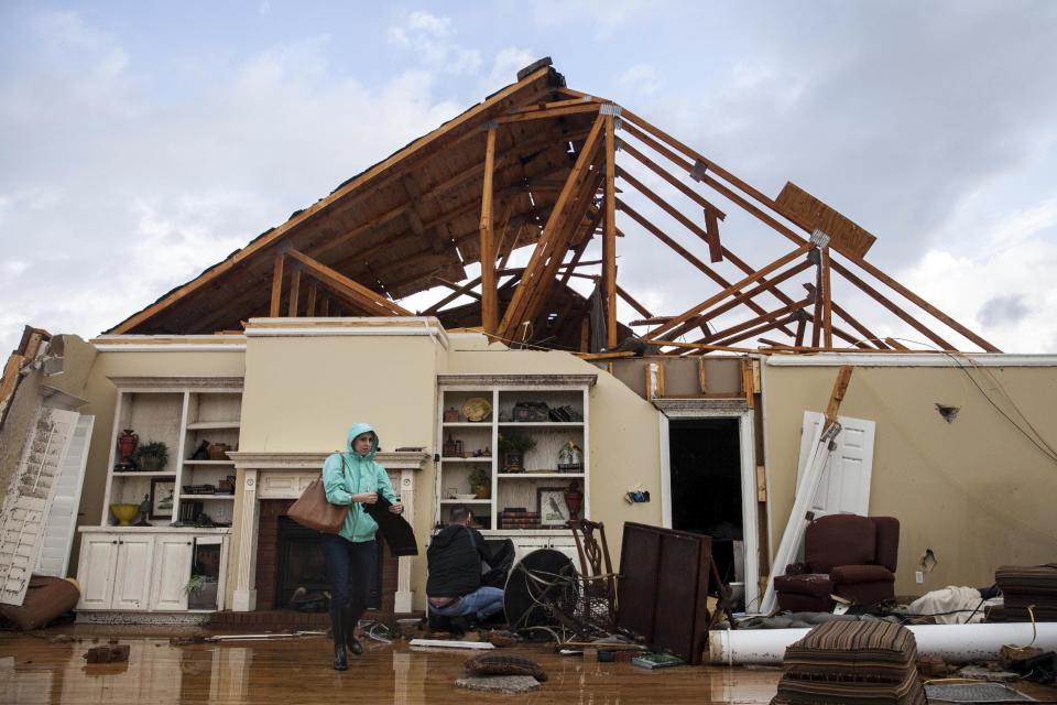 Marilyn Bullard walks through what used to be a living room that was damaged by a tornado Sunday, Jan. 22, 2017, in Adel, Ga. (AP Photo/Branden Camp)