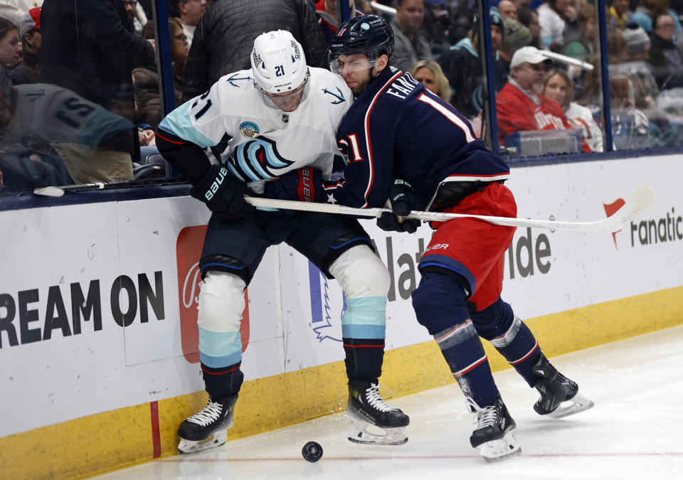 Columbus Blue Jackets forward Adam Fantilli, right, checks Seattle Kraken forward Alex Wennberg during the first period NHL hockey game in Columbus, Ohio, Saturday, Jan. 13, 2024. (AP Photo/Paul Vernon)