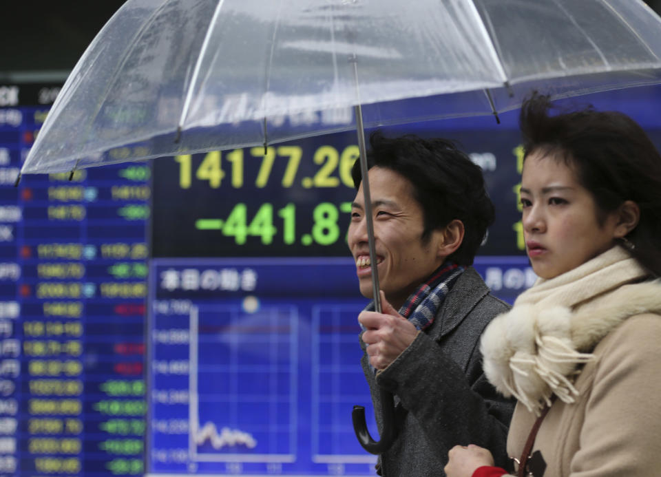 People walk by an electronic stock board of a securities firm in Tokyo, Tuesday, Feb. 4, 2014. Weakness in U.S. and Chinese manufacturing sent Asian stock markets sharply lower Tuesday. (AP Photo/Koji Sasahara)