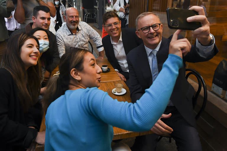 El dirigente opositor australiano Anthony Albanese se toma una selfie con seguidores en un café en Sídney, jueves 21 de abril de 2022. 