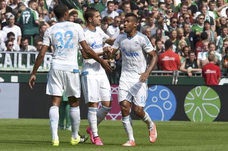 Schalke 04's players Joel Matip (L), Roman Neustaedter and Eric-Maxim Choupo-Moting (R) celebrate after Werder Bremen scored an own goal during the German Bundesliga first division soccer match in Bremen, Germany August 15, 2015. REUTERS/Fabian Bimmer