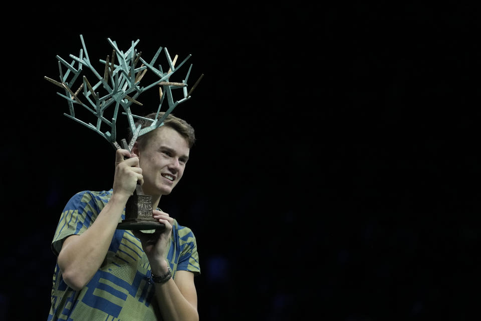 Denmark's Holger Rune celebrates with this trophy after defeating Serbia's Novak Djokovic in their Paris Masters final at the Accor Arena, Sunday, Nov. 6, 2022 in Paris. Rune won 3-6, 6-3, 7-5. (AP Photo/Thibault Camus)