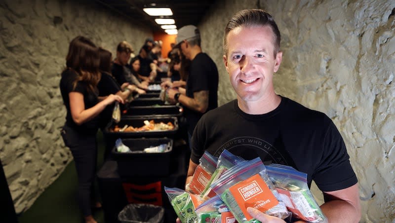 Trevor Farnes, MTN OPS CEO and co-founder, poses for a portrait at MTN OPS in Fruit Heights on Tuesday, April 16, 2024. In the background, employees put meal kits together for the photo shoot. MTN OPS has donated millions of meals to those in need.
