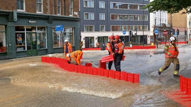 London Fire Brigade crews using flood barriers to divert water caused by a burst  water main in Pentonville Road